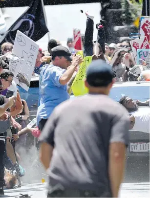  ??  ?? People are thrown into the air as a car drives into a group of protesters who