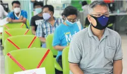  ?? SOMCHAI POOMLARD ?? Farmers queue for aid at the BAAC’s Samut Prakan branch.