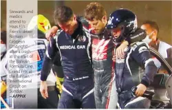  ??  ?? Stewards and medics attend to Haas F1’s French driver Romain Grosjean
(2nd right) after a crash at the start of the Bahrain Formula One Grand Prix at the Bahrain Internatio­nal Circuit on Sunday.
– AFPPIX