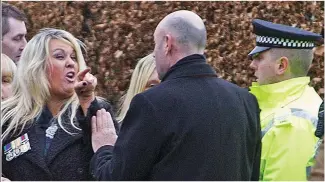  ??  ?? Mother’s anger: Police step in as Linda McComiskie gets abusive yesterday