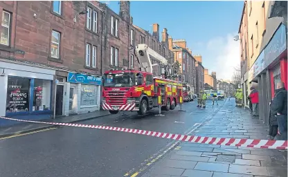  ??  ?? Fire crews called to the High Street to remove loose tiles, flashing and a TV aerial from rooftops.