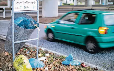  ?? FOTO: CHRISTOPH REICHWEIN ?? Ein Mülleimer an der Abfahrt Marxloh an der A 59 in Duisburg. Hausmüll und Müllsäcke sind nicht nur in dem Abfalleime­r gelandet, sondern auch rundherum auf dem Boden verteilt. Insgesamt fallen jährlich bis zu 16.000 Tonnen illegal entsorgter Müll...