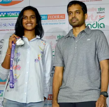  ?? — ASIAN AGE ?? P.V Sindhu and coach Pullela Gopichand after arriving in Hyderabad following her silver medal effort in the World Badminton Championsh­ips in Glasgow.