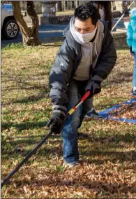  ??  ?? Michael Angtuaco helps rake the grounds of St. Joseph Center.