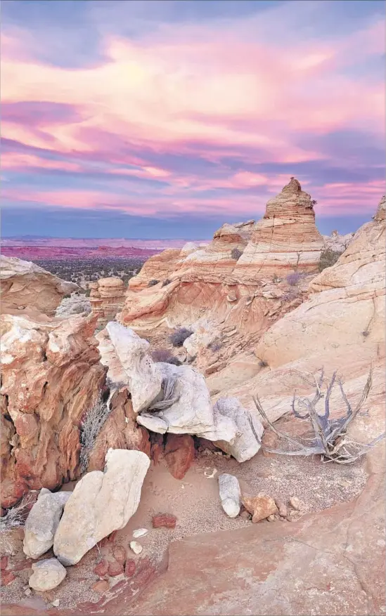  ?? James Hager Getty Images / Robert Harding World Imagery ?? A PURPLE- AND ORANGE-TINGED SUNSET caps the craggy beauty of the Coyote Buttes wilderness area at Vermilion Cliffs National Monument in Arizona.