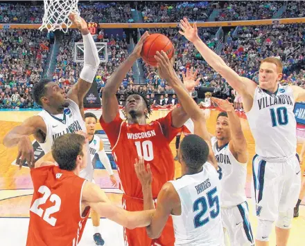  ?? BILL WIPPERT/ASSOCIATED PRESS ?? Wisconsin forward Nigel Hayes (10) goes to the basket against Villanova’s Darryl Reynolds, left, Donte DiVincenzo (10) and Mikal Bridges (25) during Saturday’s NCAA Tournament game. The No. 8-seeded Badgers won and will face No. 4 Florida next.