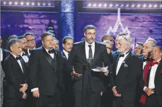 ??  ?? Producer Orin Wolf, center, delivers the acceptance speech Sunday after “The Band’s Visit,” based on an Israeli film, wins the Tony Award for best musical, in New York.