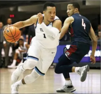  ?? LAURENCE KESTERSON — THE ASSOCIATED PRESS ?? Villanova guard Jalen Brunson (1) first half Wednesday. drives past Penn guard Darnell Foreman (4) during the