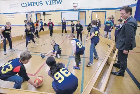  ?? ADRIAN LAM, TIMES COLONIST ?? Education Minister Rob Fleming watches Grade 5 students play a game called Gaga ball before announcing a $2.4-million seismic upgrade for Campus View Elementary School in Saanich. Students will not need to be moved: Most of the inside work will be done...