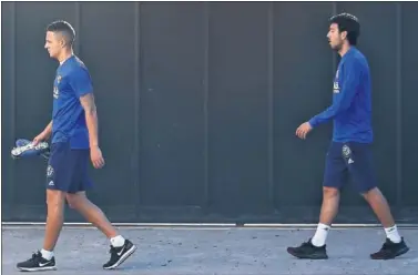  ??  ?? CABIZBAJOS. Los jugadores del Valencia, Rodrigo y Parejo, ayer camino del gimnasio.