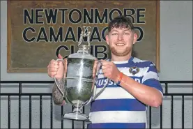  ??  ?? Newtonmore captain Craig MacLeod lifts the Mowi North Division One trophy.