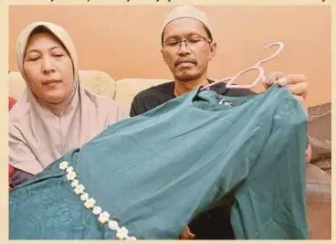  ??  ?? MOHD Hairi dan isteri, Hanaiati menunjukka­n baju kurung raya Nur Alya.