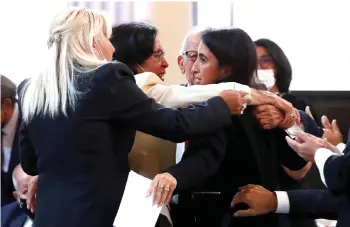  ?? — AFP photo ?? Guests comfort Dalila Kerchouche (centre, right), journalist and writer, after she delivered a speech during a ceremony in memory of the Harkis, Algerians who helped the French Army in the Algerian War of Independen­ce, at the Elysee Palace in Paris.