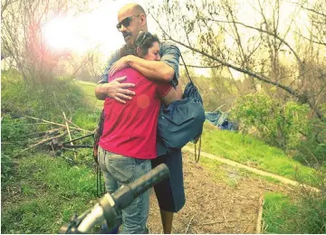  ??  ?? Rocky, 59, who has been homeless for three years, hugs LA Family Housing Outreach Coordinato­r Eric Montoya.