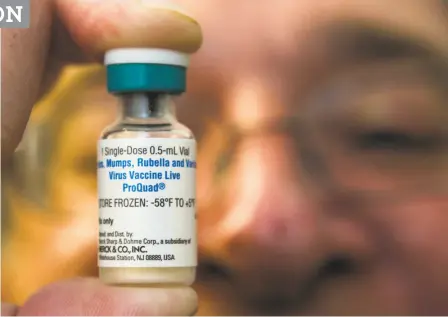  ?? Damian Dovarganes / Associated Press ?? A pediatrici­an holds a dose of the
measlesmum­ps-rubella (MMR)
vaccine, which some parents do
not allow their children to get after filing for
a state exemption, thus leaving their kids and others they come in contact with vulnerable
to these...