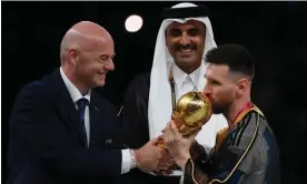  ?? Franck Fife/AFP/Getty ?? Argentina's Lionel Messi kisses the World Cup trophy as Fifa’s Gianni Infantino and Qatar's emir look on. In 2026 there will be 72 games to eliminate 16 teams. Photograph: