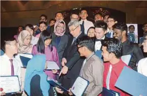  ?? PIC BY HALIM SALLEH ?? Plantation Industries and Commoditie­s Minister Datuk Seri Mah Siew Keong presenting MREPC scholarshi­ps to students at an event in Kuala Lumpur yesterday.