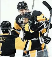  ?? GENE J. PUSKAR/AP ?? The Penguins’ Bryan Rust, center, celebrates his goal with Justin Schultz, left, and Evgeni Malkin during Monday’s win.