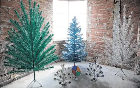  ?? Molly Glentzer / Staff ?? Though silver was the most popular color of aluminum tree, fanciful options included Yulecraft’s blue Fantasy Tree, center, which has hooped branches.