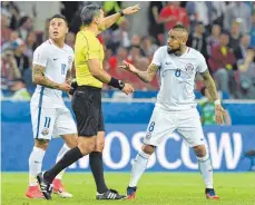  ?? FOTO: AFP ?? Arturo Vidal (re.) ist sich seiner Sache gegenüber Schiedsric­hter Damir Skomina recht sicher. Eduardo Vargas sucht schon Hilfe auf der Videowand.