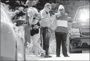  ?? AP/St. Louis Post-Dispatch/J.B. FORBES ?? A Jefferson County sheriff’s deputy speaks Wednesday with distraught relatives at the scene of a standoff south of Cedar Hill, Mo. A Missouri man has been arrested after police said he stood over a dead woman’s body more than five hours as he held...