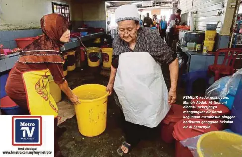  ?? FOTO: ?? PEMILIK kedai nasi ayam, Mimah Abdul, 76 (kanan) dibantu pekerjanya mengangkat air untuk kegunaan membasuh pinggan berikutan gangguan bekalan air di Semenyih.