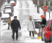  ?? PETE BANNAN – DIGITAL FIRST MEDIA ?? West Chester resident Bob Loper chats with neighbors Susan Batchelor and Park Messikomer as they shovel their car out on North New Street in West Chester Tuesday morning. Snow totals were lowered by sleet and rain that fell during the storm.