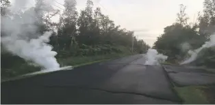  ?? U.S. GEOLOGICAL SURVEY VIA THE ASSOCIATED PRESS ?? Steam rises from cracks in the road shortly before a fissure opened up Friday on Kaupili Street in Pahoa, Hawaii.