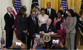  ?? Photograph: Alex Brandon/AP ?? Joe Biden signs an executive order on police reform in the East Room of the White House on Wednesday.