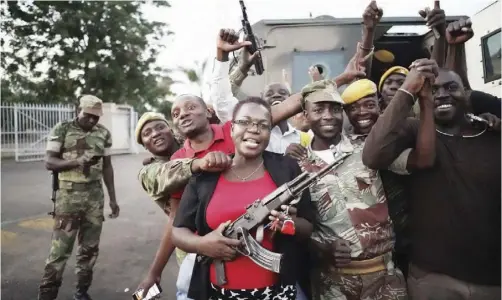  ??  ?? People and soldiers celebrated after news of Mr. Mugabe's resignatio­n trickled out.