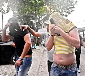  ?? SUNSTAR FOTO / AMPER CAMPAÑA ?? ‘SKIMMERS’. An NBI 7 operative escorted two of the three Romanian nationals who were believed to be behind ATM skimming in Cebu.