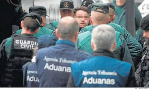  ?? EFE / BRAIS LORENZO ?? Uno de los detenidos en San Roque es conducido, entre fuertes medidas de seguridad, hacia el interior de los juzgados de Orense, ayer.