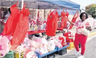  ?? ERROL CROSBY ?? Ionie Beckford tries to catch last-minute sales on Valentine’s Day on White Church Street in Spanish Town yesterday. Beckford, who sells baskets that she designs along with other items like teddy bears, said sales were similar to previous years despite the pandemic.