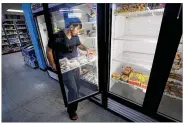  ?? CHARLIE NEIBERGALL / AP ?? Hardik Kalra stocks meat in a cooler at a local super market in Des Moines, Iowa. Shoppers lately have seen the costs of meat, eggs and even potatoes soar.