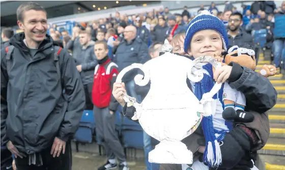  ??  ?? A Blackburn fan holds an FA Cup replica trophy during a match this year.