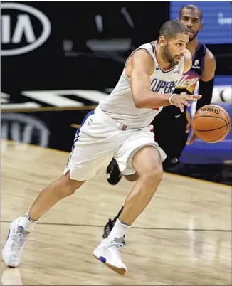  ?? Ralph Freso Associated Press ?? NICOLAS BATUM dribbles the ball up the court after stealing it from Chris Paul. Batum guarded everyone on the Suns from Paul to center Deandre Ayton and hit a game- clinching three- pointer.