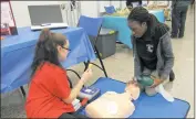  ??  ?? North Point High School junior Christina Gerow, 17, shows Adenike Oluyede, 16, a sophomore, how to properly administer CPR during the H.I.T.S. Expo. Both are enrolled in the North Point Academy of Health Profession­als program.