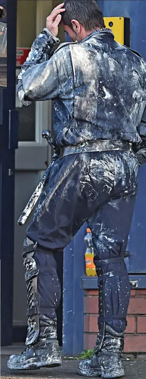  ??  ?? Exhausted: An officer, spattered in paint, emerges from the riot-torn jail