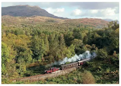  ?? ?? Left: The vintage trains may have been the stars, but Double Fairlie Merddin Emrys was at work on the Mountain Spirit service train on October 8, seen emerging from the woodlands at Whistling Curve. OWEN HAYWARD