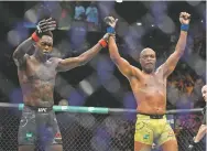  ?? ANDY BROWNBILL/ASSOCIATED PRESS ?? Nigeria’s Israel Adesanya, left, reacts after defeating Brazil’s Anderson Silva at the UFC 234 event Sunday in Melbourne.