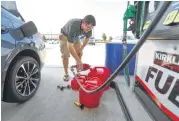  ?? Steve Gonzales / Houston Chronicle ?? Chris Mathew fills his vehicle and five gasoline cans at Costco in preparatio­n for a possible hurricane.