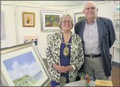  ??  ?? David is pictured (below right) with Charnwood Mayor Coun Christine Harris (below left) alongside a framed seascape painted by Charles Evans, that was raffled on day two of the exhibition with the proceeds donated to Rainbows charity.