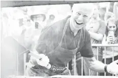  ?? — Reuters photo ?? Biden smiles for the media while frying steaks at the Polk County Democrats’ Steak Fry in Des Moines, Iowa.