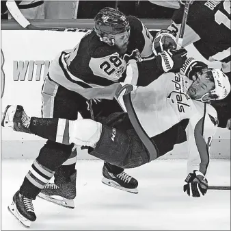  ?? PUSKAR/THE ASSOCIATED PRESS] [GENE J. ?? Ian Cole of the Penguins checks Justin Williams of the Capitals during the third period.