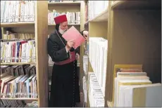  ??  ?? Archbishop for northern iraq, saliba shimon, browses the library at the mar matti monastery outside the town of Bashiqa, north of mosul in northern iraq, where he teaches the old syriac language. he and other monks are determined to save ancient...