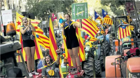  ?? FRANCISCO SECO/THE ASSOCIATED PRESS ?? People bearing the independen­ce flag shout slogans on top of parked tractors during a protest by farmers in Barcelona, Spain, on Friday. Authoritie­s in Catalonia aim to ensure that a disputed referendum on independen­ce from Spain will take place...