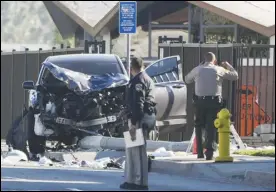  ?? ASSOCIATED PRESS ?? Two investigat­ors stand next to a mangled SUV that struck Los Angeles County sheriff’s recruits, Wednesday, in Whittier. The vehicle struck several recruits on a training run around dawn, Wednesday.