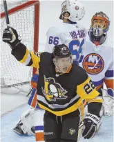  ?? AP PHOTO ?? EXTRA SPECIAL: Matt Hunwick celebrates his overtime goal on Jaroslav Halak and the Islanders, giving the Penguins a 4-3 victory last night.