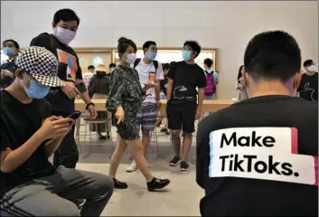  ?? AP PHOTO/NG HAN GUAN ?? A visitor to an Apple store wears a t-shirt promoting Tik Tok in Beijing on July 17.