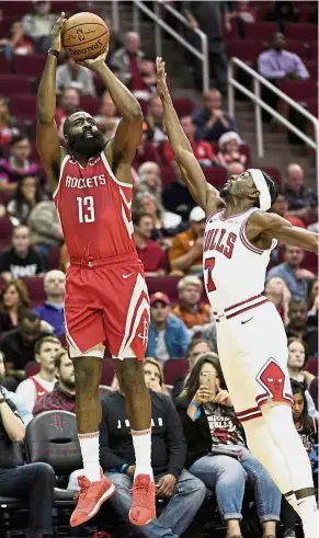  ??  ?? Up, up and away: Rockets’ James Harden (left) shoots as Chicago Bulls’ Justin Holiday defends during their NBA game in Houston on Saturday. Rockets won 121-105. — AP